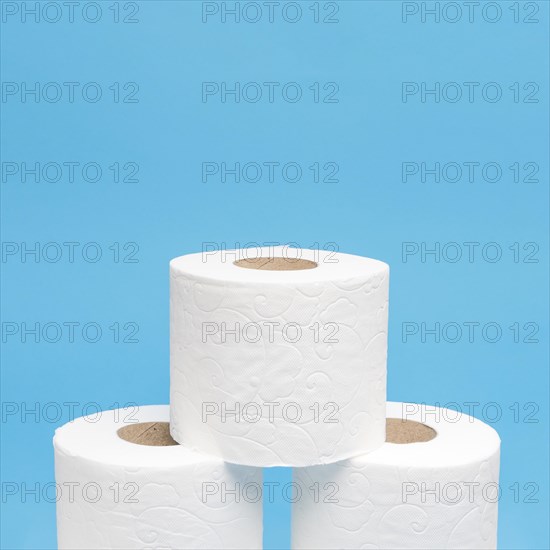 Front view three stacked toilet paper rolls with copy space