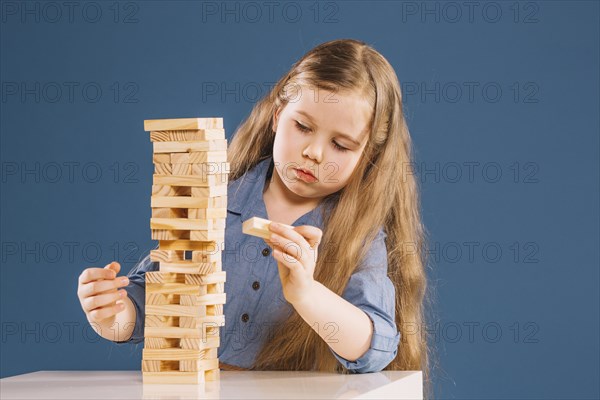 Cute girl removing blocks from jenga tower