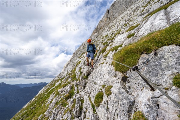 Climber on a climb secured with a steel rope
