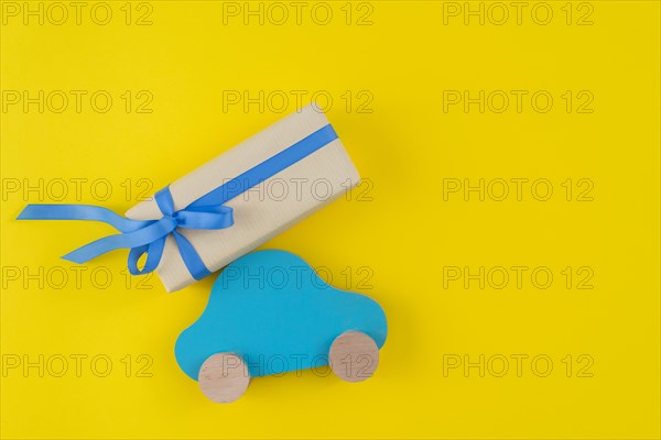 Gift box with toy car yellow table