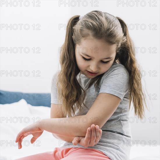 Close up girl touching her elbow with hands