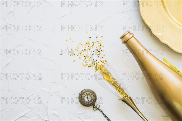 Spangles scattered from glass with bottle