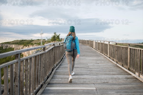 Back view tourist walking down bridge