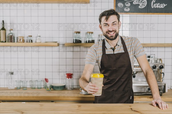 Cheerful barista with cup