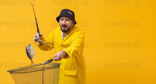 Front view fisherman holding fishing rod net with copy space