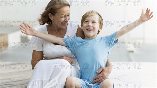 Smiley woman holding grandson