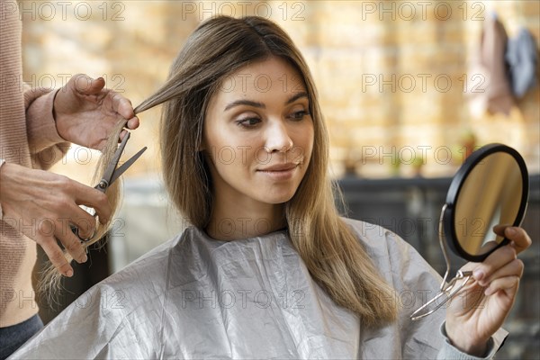 Beautiful woman getting her hair cut home by hairstylist