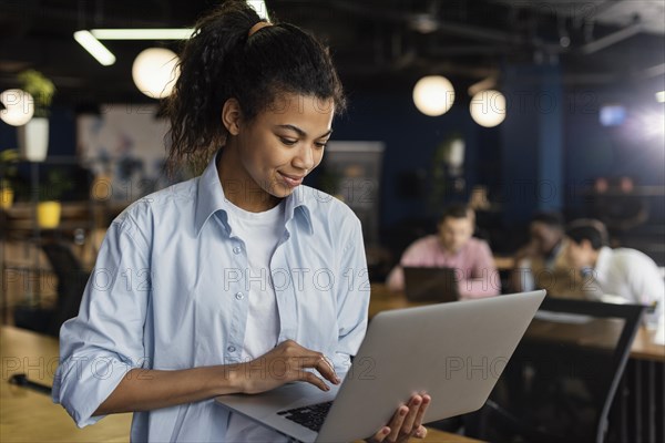 Smiley woman holding laptop office working