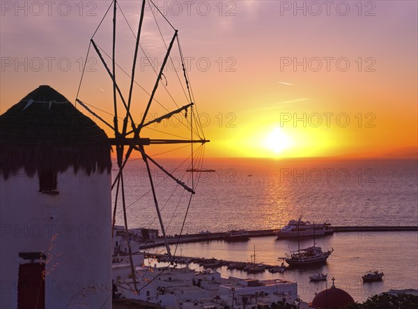 Famous traditional Greek windmill overlook port and harbor of Mykonos