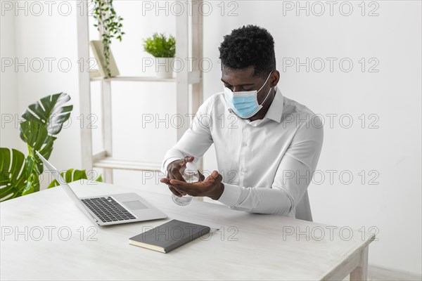 African american man wearing mask cleaning his hands