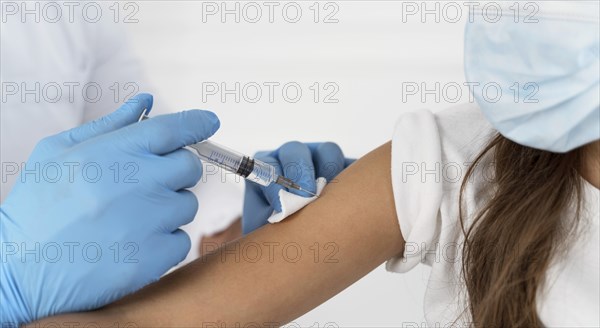 Close up male doctor vaccinating girl
