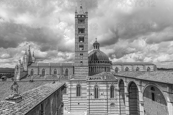 Dark clouds over the cathedral of Siena with its black and white striped marble facade