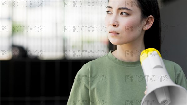 Asian woman protesting holding megaphone