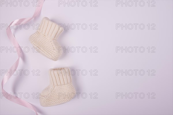 Baby socks with pink ribbon flat lay