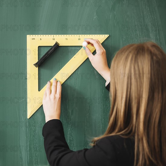 Woman drawing with triangular ruler blackboard