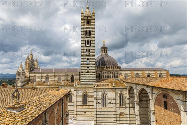 Dark clouds over the Siena Cathedral with its black and white striped marble facade