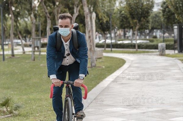 Man riding bike while wearing medical mask