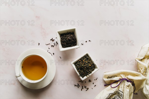 Dried tea herbs bowl with black tea marble texture backdrop