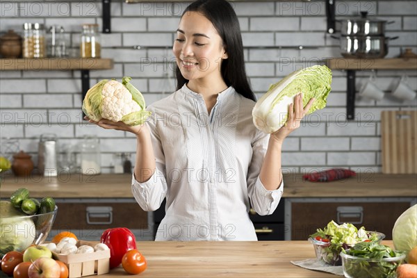 Portrait asian woman holding green cauliflower lettuce kitchen