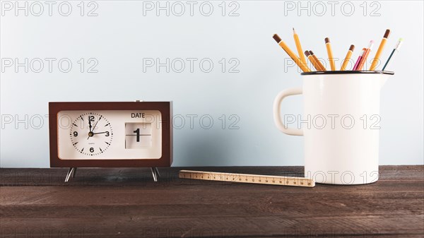 Ruler pencils near clock