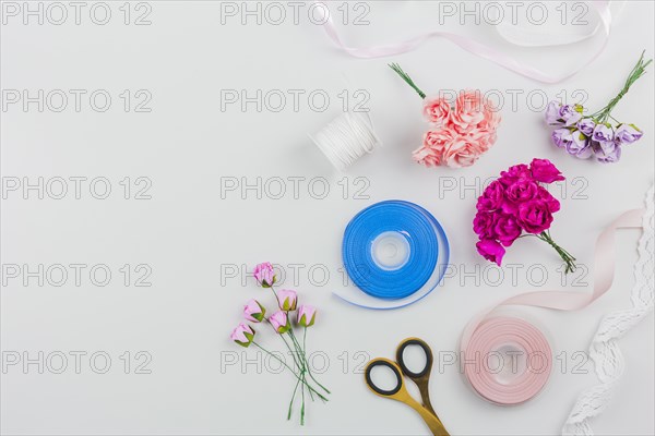 Artificial roses scissor with blue pink ribbon white background