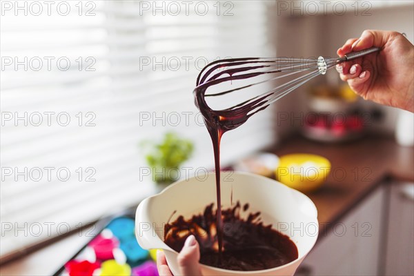 Crop hands mixing batter with whisk