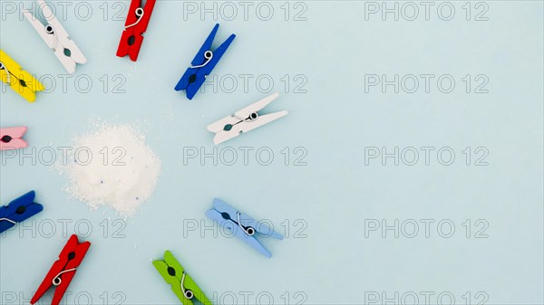 Flat lay colorful clothes pins surrounding detergent