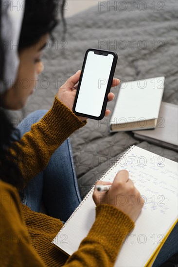 High angle teenage girl using smartphone online school