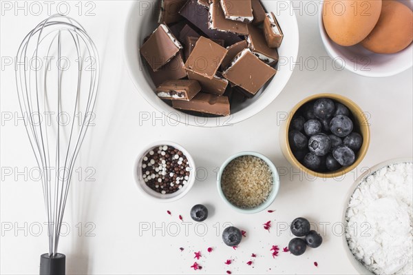 Ingredients making cake with whisk white background