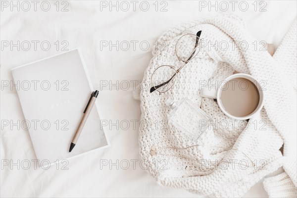 Notebook with pen it near sweater with things bedsheet