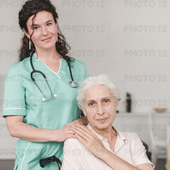 Portrait female nurse with her senior patient sitting wheel chair