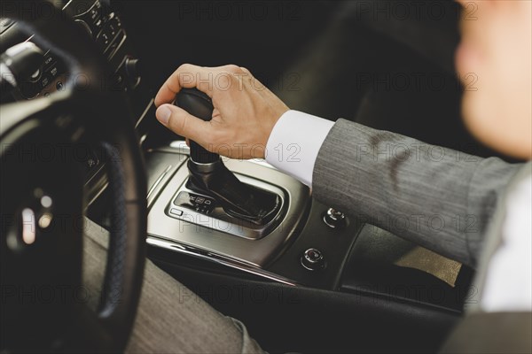 Elevated view businessman driving car moving transmission shift gear