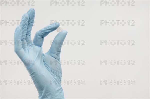 Close up hand holding pill with copy space