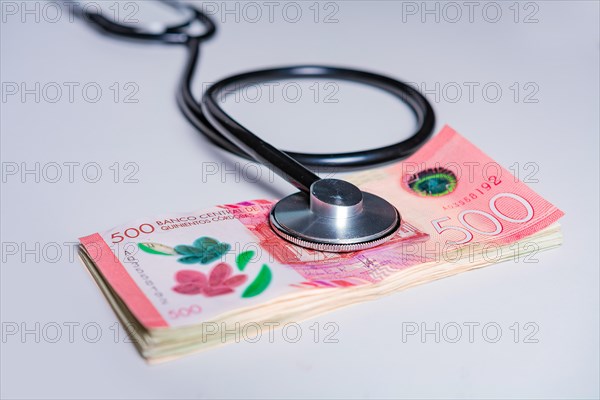 Close up of stethoscope on 500 cordobas bills isolated. Nicaraguan medical healthcare cost concept
