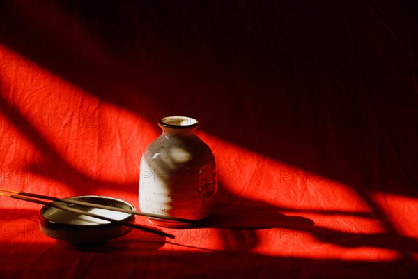 Light and shadows cast on incense sticks in a porcelain platter