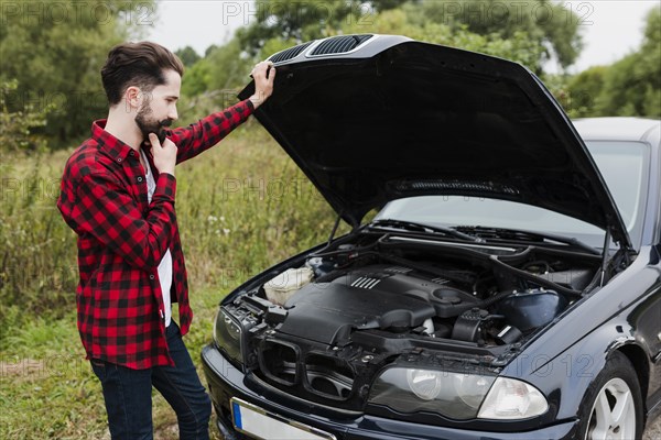 Man leaning open car hood