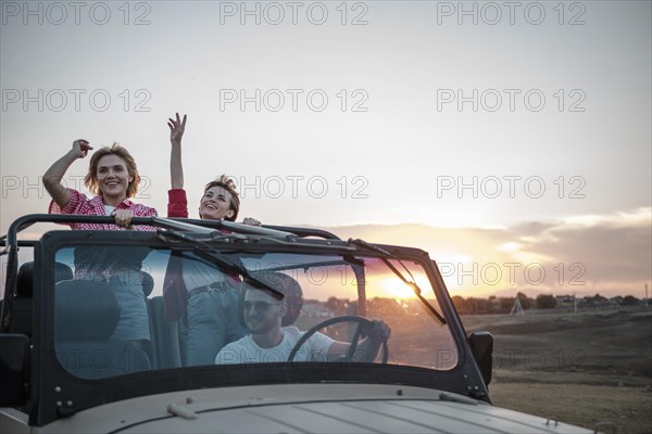 Three friends traveling by car having fun