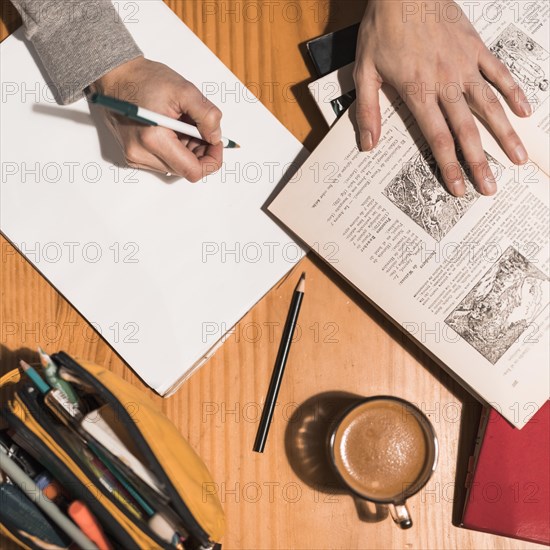 Crop hands making notes during studies