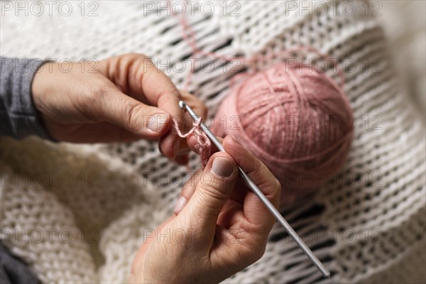 High view person knitting with pink thread