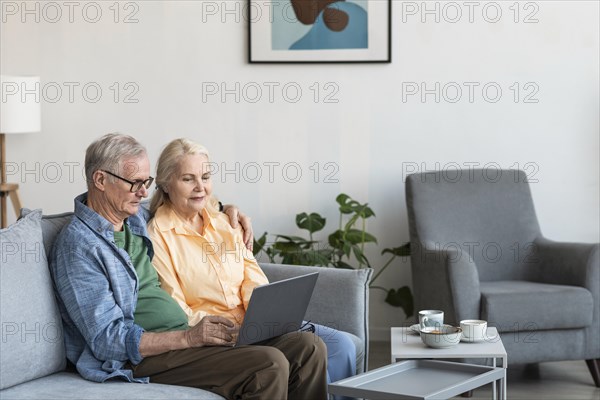 Medium shot retired couple with laptop