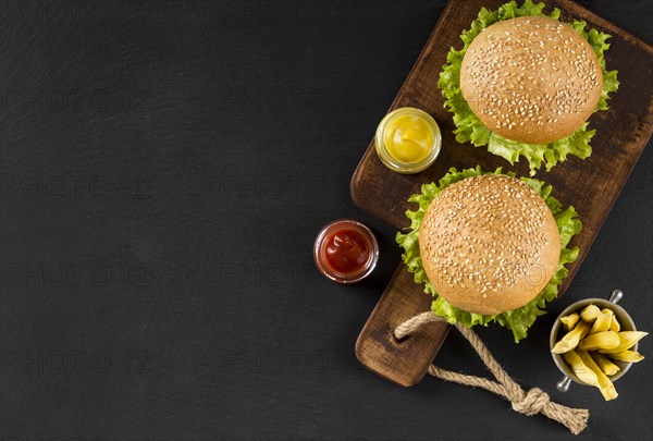 Top view burgers fries cutting board with copy space