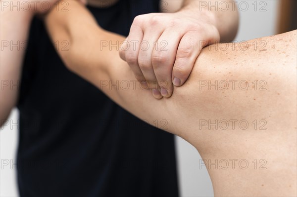 Front view physiotherapist massaging man s arm