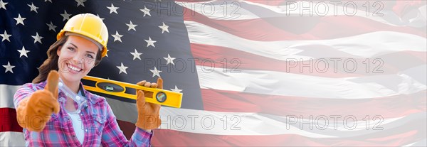 Female contractor wearing blank yellow hardhat and gloves over waving american flag background banner