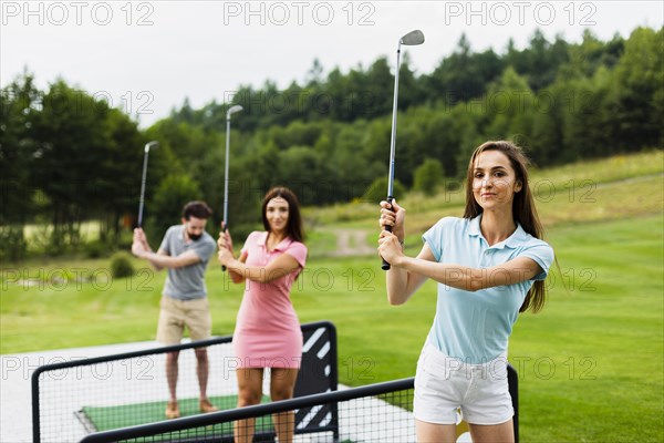 Front view young golfers with stick up