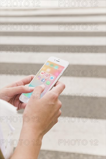 Person s hand holding cellphone with social media notifications screen