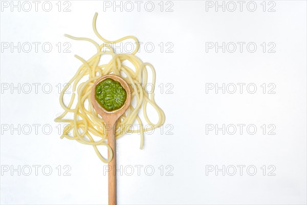 Pesto in cooking spoon and spaghetti