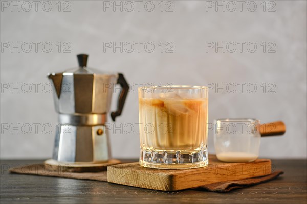Glass with iced coffee on a wooden table