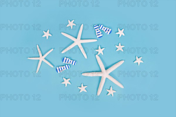 White starfish and sandals on blue background