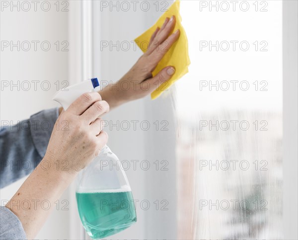 Side view woman washing window