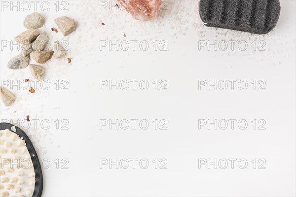 Overhead view salt massage brush pumice stone himalayan pink rock salt isolated white backdrop